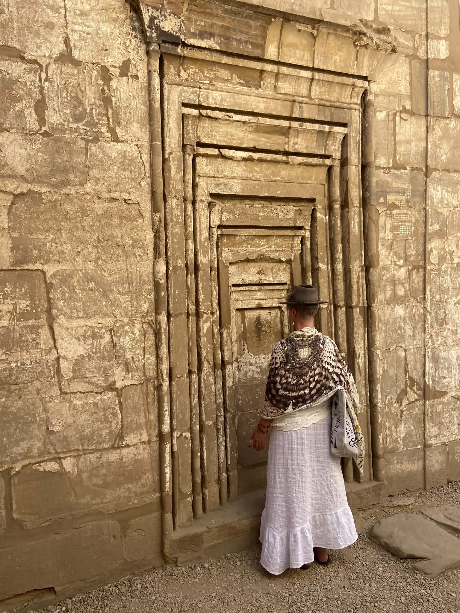 Mel standing before a sequence of ancient Egyptian temple doorways