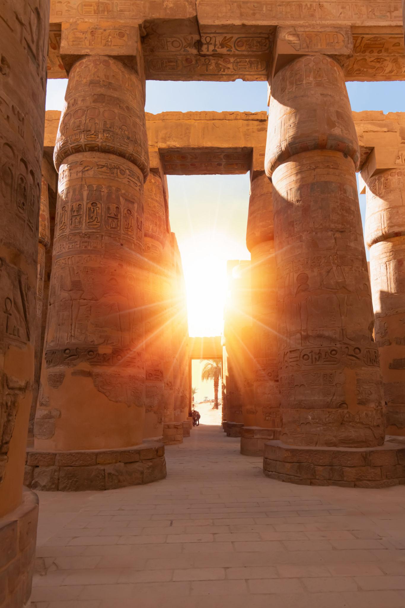 Golden sunlight streaming through the columns of Karnak temple
