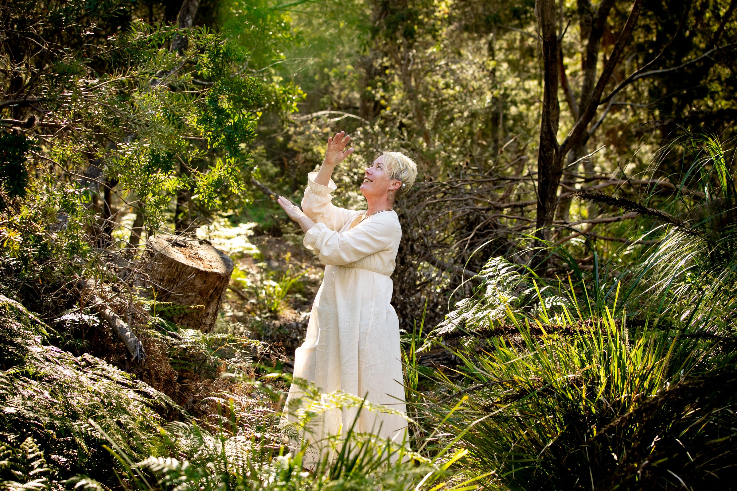 Mel standing among the trees in soft natural light