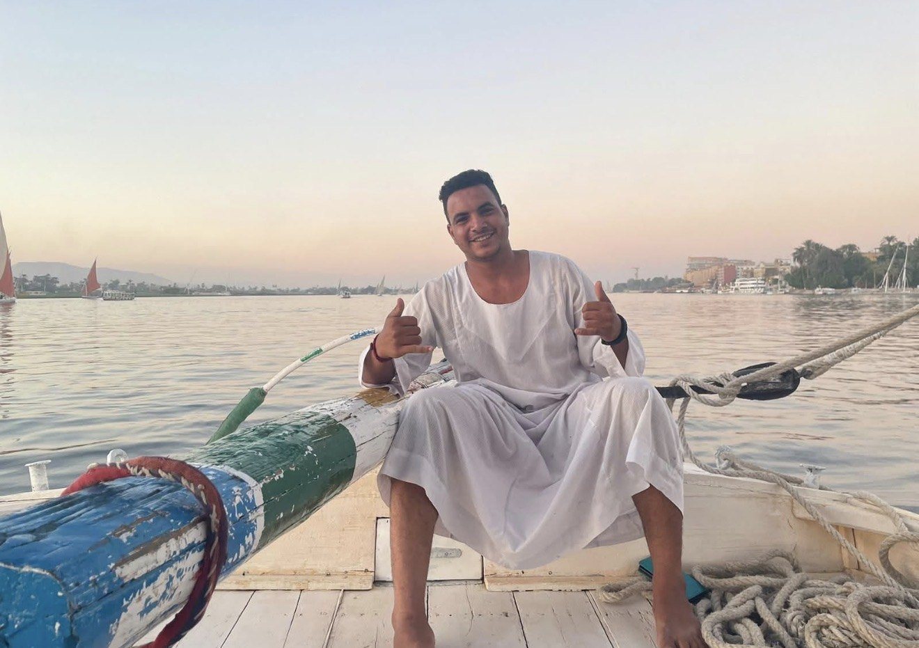 A smiling felucca sailor on the Nile at sunset