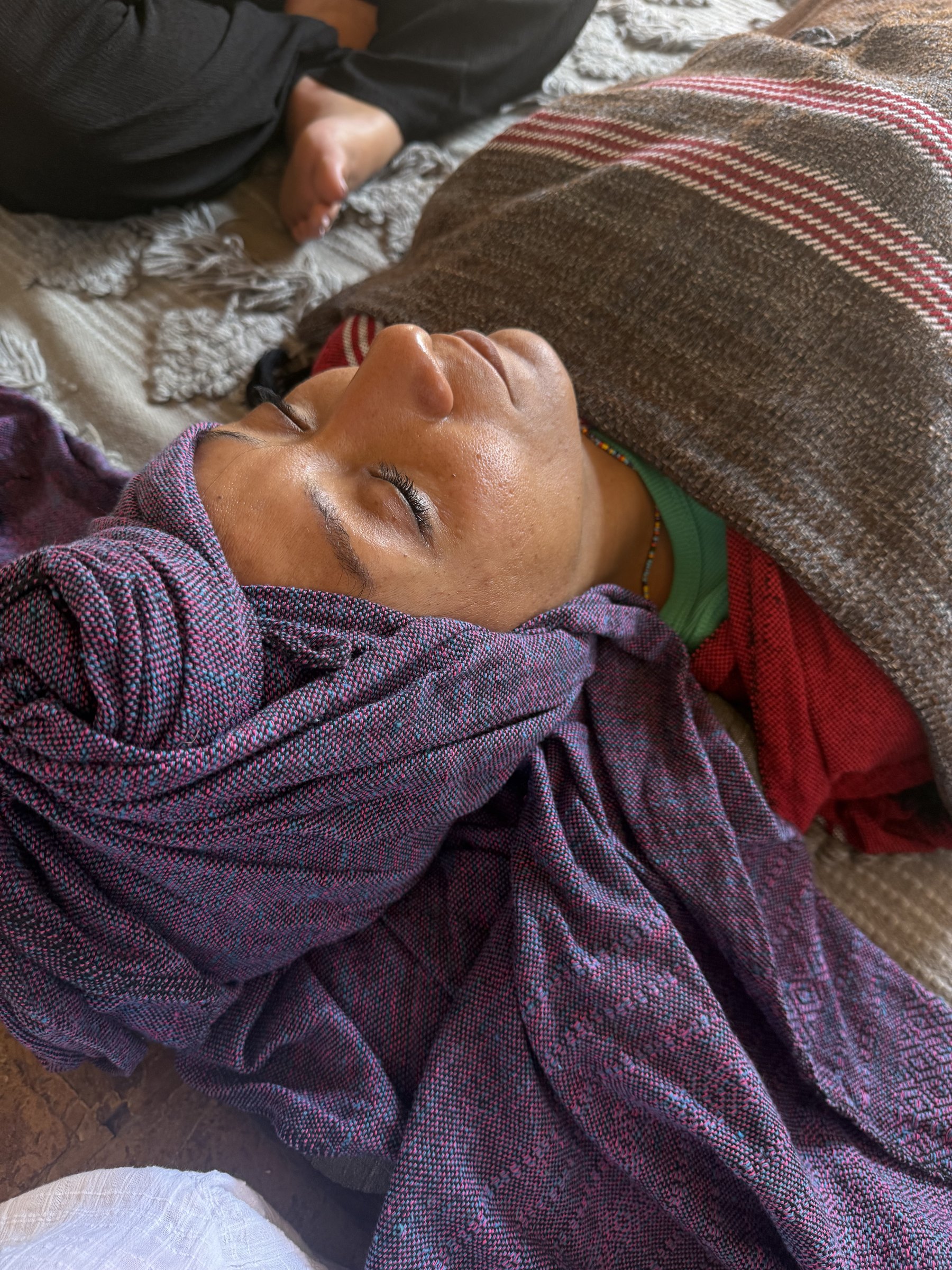 A woman resting and receiving care in ceremony